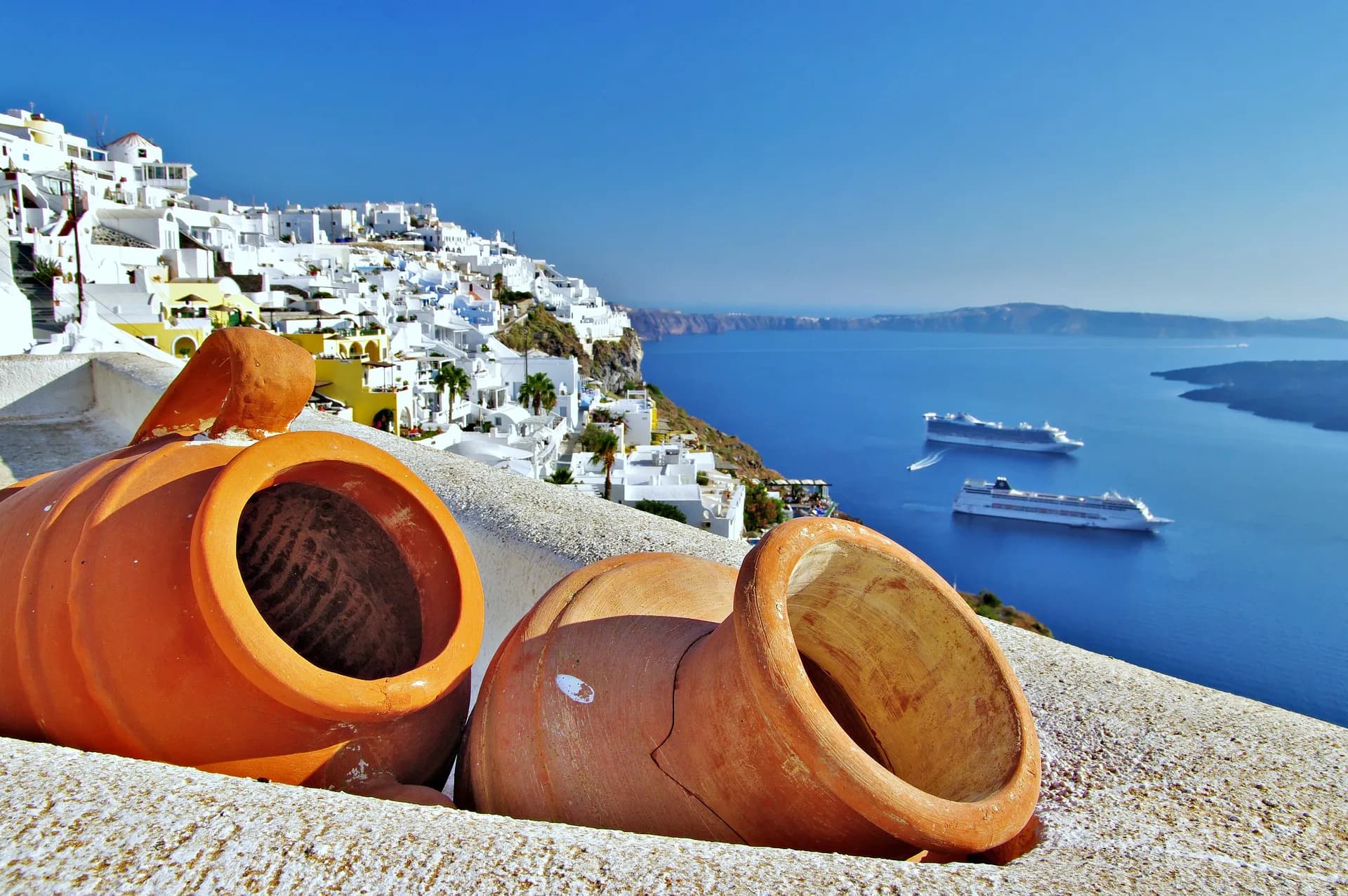 Terracotta pots on a wall above the Santorini caldera at Fira