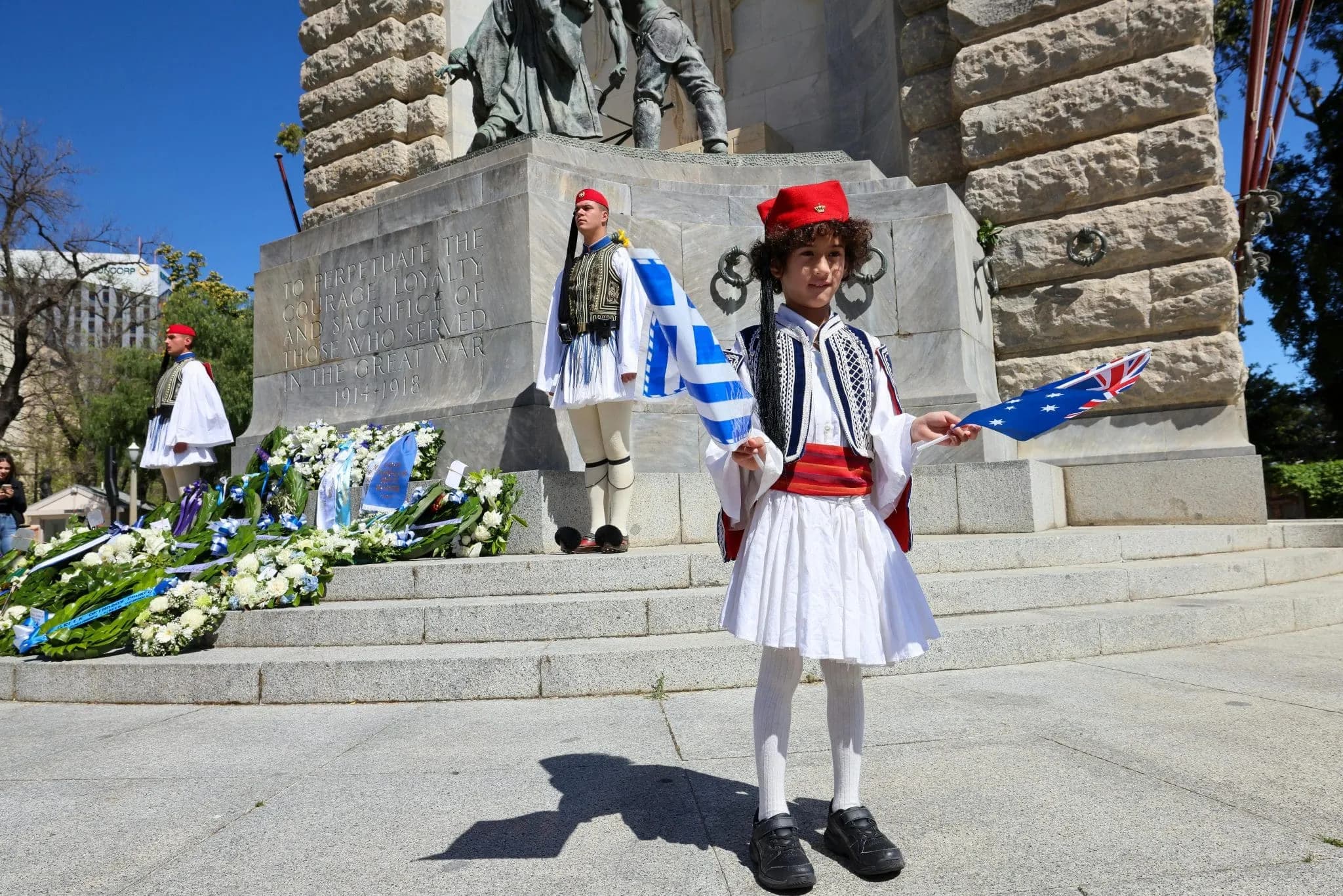 Boy in Traditional Greek Uniform Holding a Greek Flag during Independence Day Celebrations