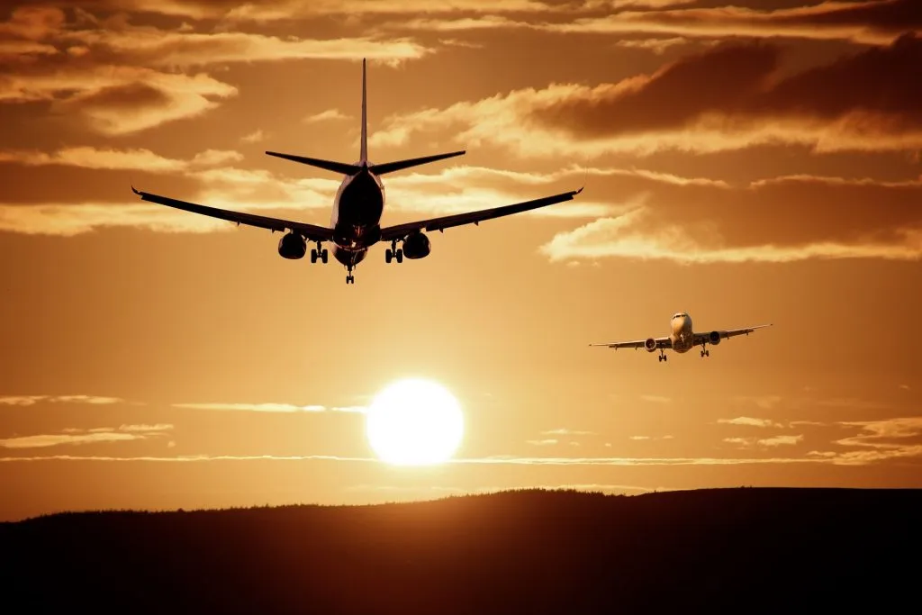 Airplane leaving over a sunset