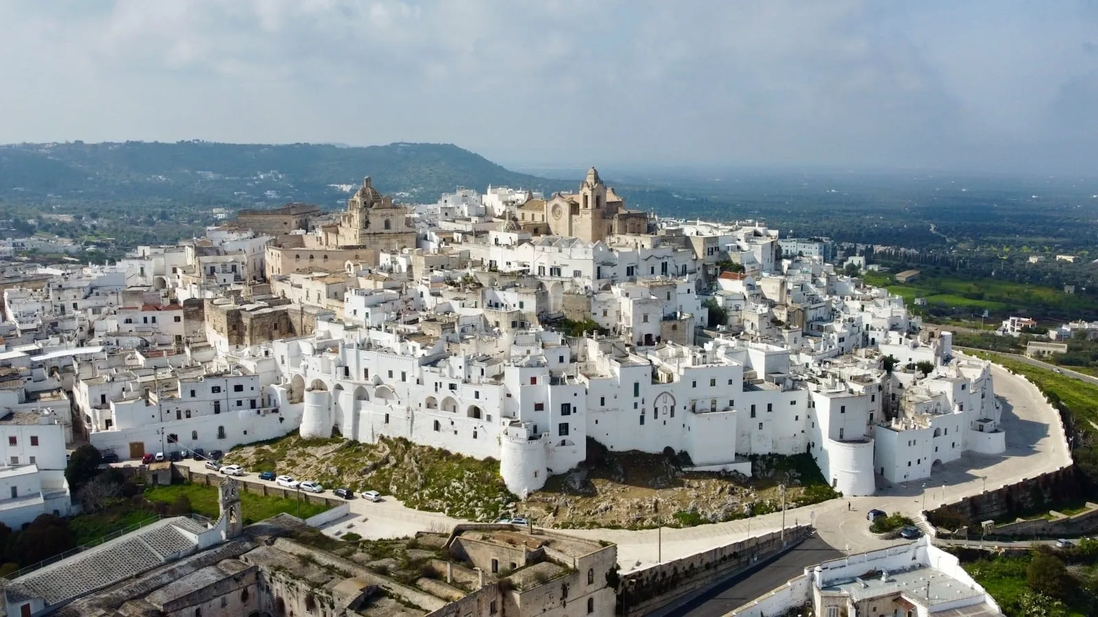 The whitewashed hilltop old town of Ostuni in Puglia, southern Italy, surrounded by olive-grove countryside