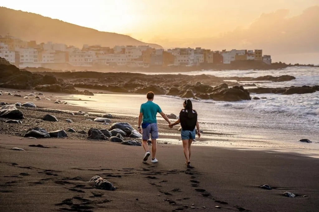 Couple Holding Hands While Walking on Shore. Puerto de la Cruz, Santa Cruz de Tenerife, Spain