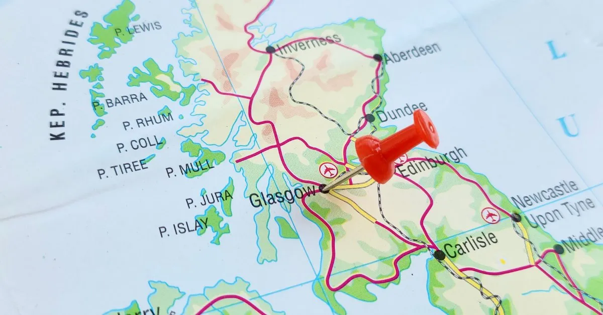 A red pushpin marking central Scotland on a road map showing Glasgow, Edinburgh, Inverness and the Hebrides.