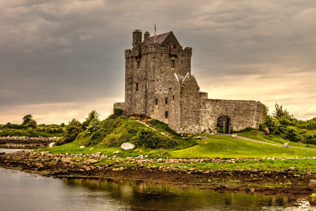 Castle in Ireland surrounded by water and on green grass
