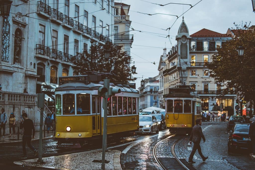 People walking and yellow trollies in Lisbon, Portugal