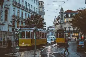 People walking and yellow trollies in Lisbon, Portugal
