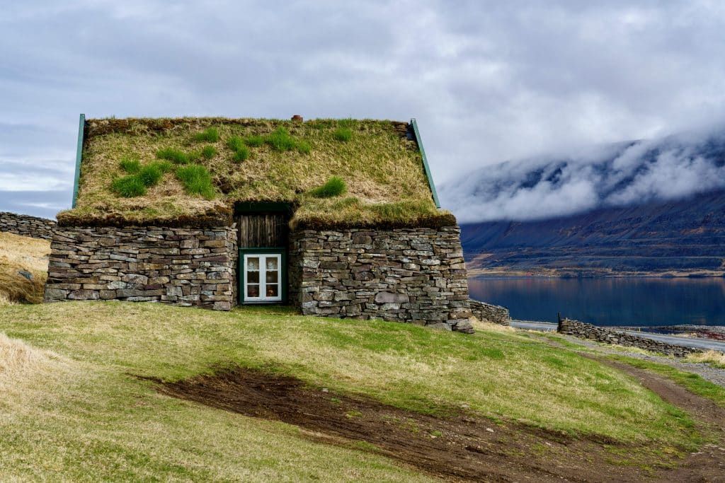 Historic Stone House with a Roof Overgrown with Grass in an Icelandic Fjord