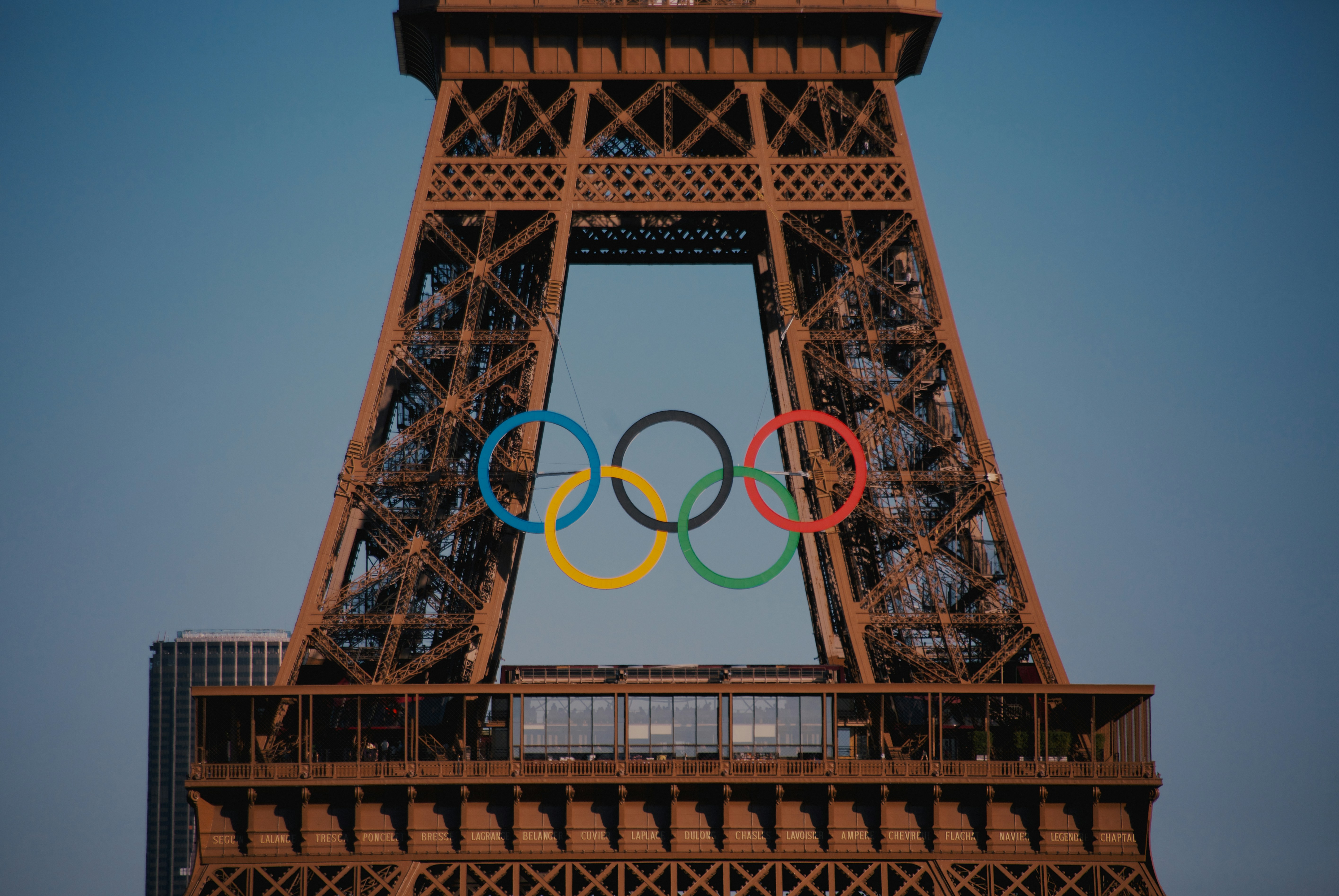 The Olympic rings are displayed on the Eiffel Tower, symbolizing the upcoming Paris 2024 Olympic Games, with parts of a cityscape in the background—an iconic sight before global events like Vikings vs Steelers 2025 capture the world's attention.