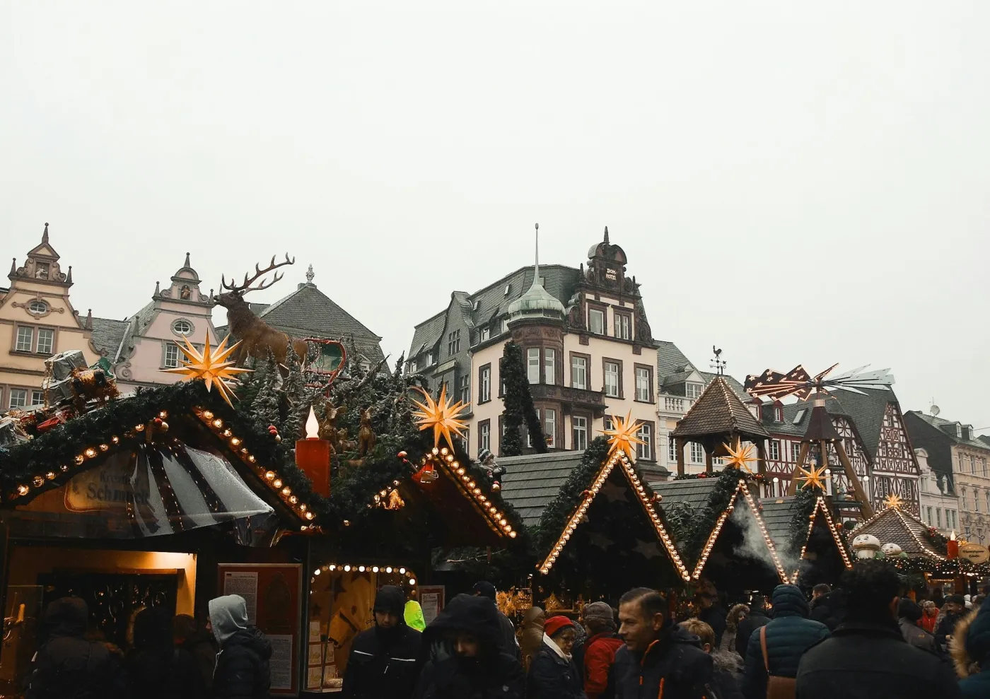 Wooden Christmas market stalls lit with Moravian stars beneath gabled German townhouses
