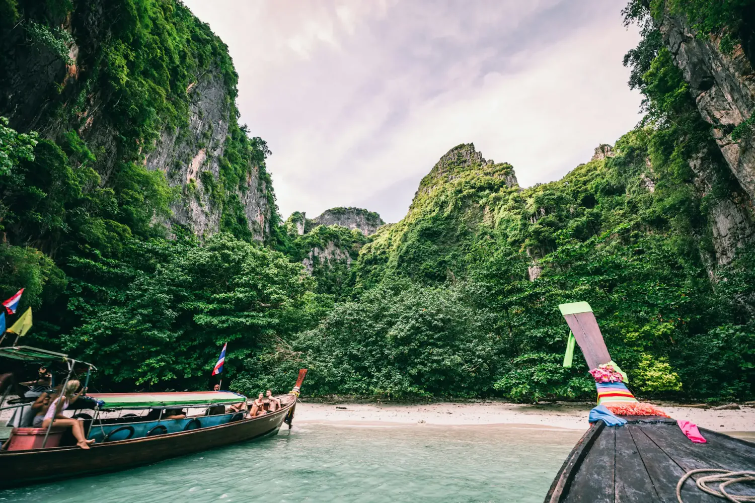 Long-tail boats in a turquoise limestone cove, southern Thailand
